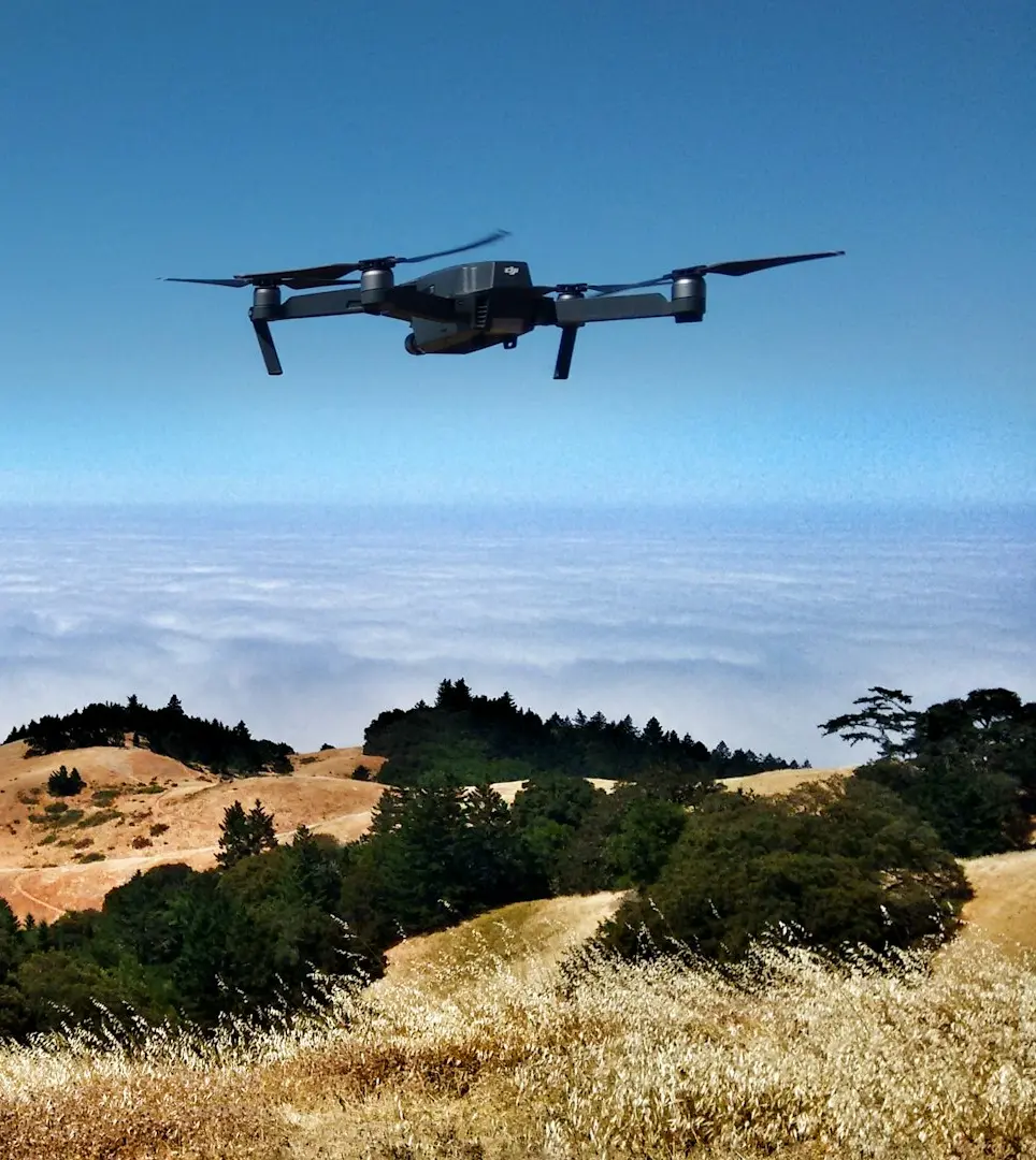 black drone on air over cloudy sky at daytime